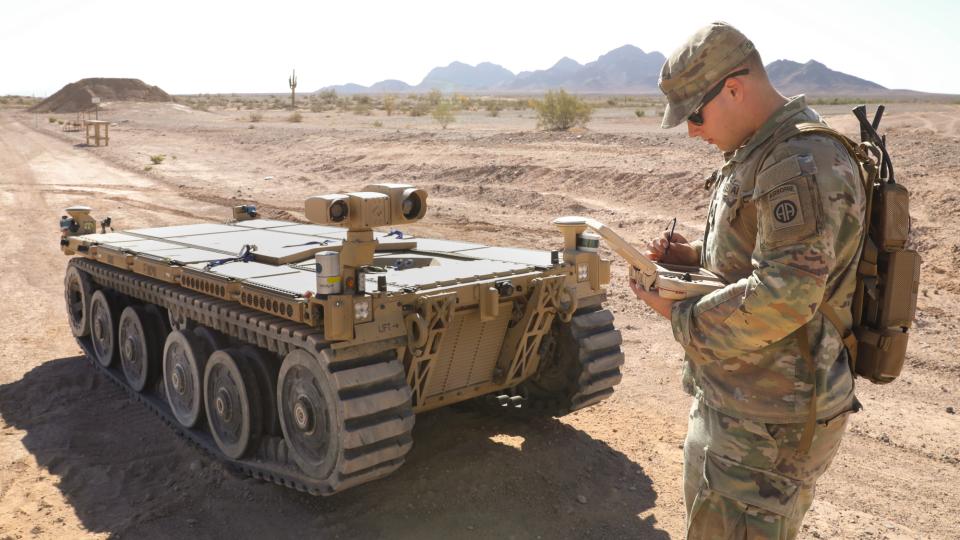 Army Pfc. Daniel Candales uses a tactical robotic controller to control an expeditionary modular autonomous vehicle as a practice exercise in preparation for Project Convergence at Yuma Proving Ground, Ariz., Oct. 19, 2021
