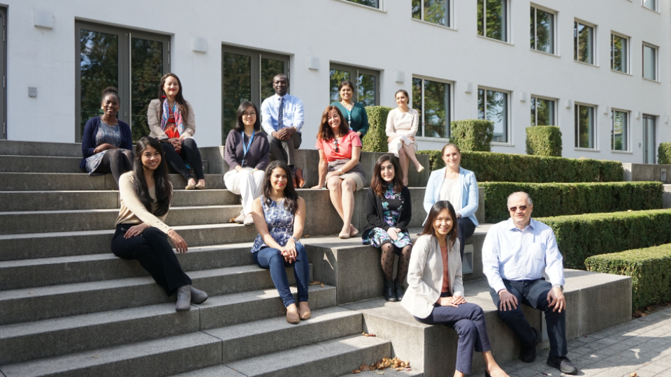 Picture of UNFCCC-UNU fellows sitting on steps, with Youssef Nassef, Director of Adaptation at UNFCCC, and Shen Xiaomeng, Director of UNU-EHS