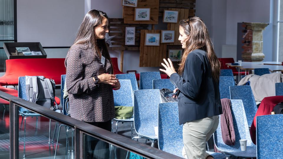 Two MACIMIDE attendees in conversation.