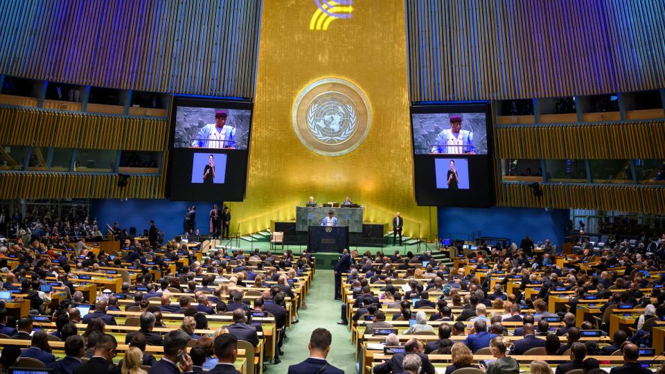 Philemon Yang (at podium and on screens), President of the seventy-ninth session of the United Nations General Assembly, addresses the opening of the Summit of the Future.