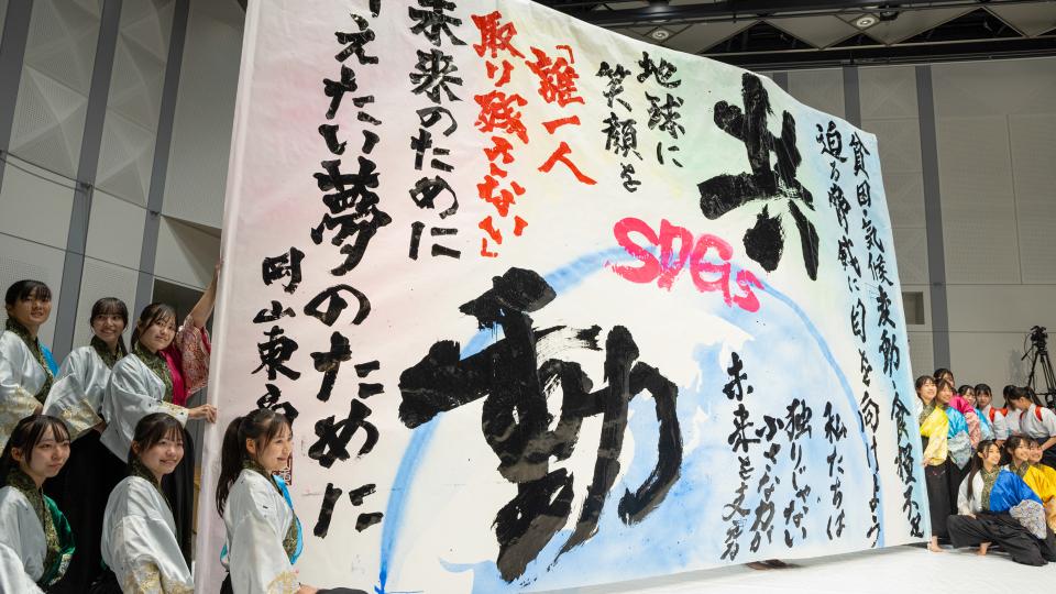 Japanese students show a giant Japanese calligraphy painting they did at the opening session of the 14th Global RCE Conference.