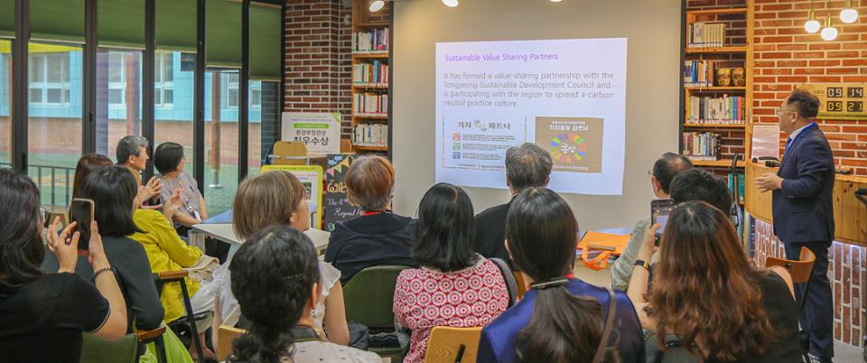 A group of people listening attentively to a man with a slide presentation.