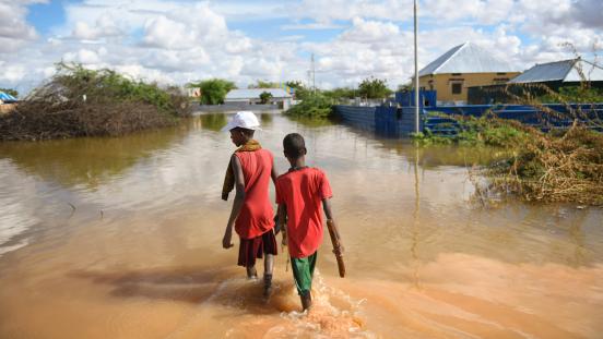 Young boys of Hawa-taako walk through a section of the flooded residential area in Belet Weyne, Somalia.