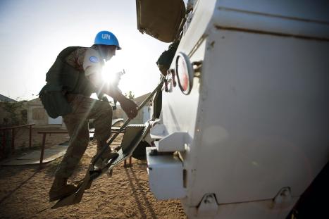 An Egyptian peacekeeper with the African Union-United Nations Hybrid Operation in Darfur (UNAMID) boards an armoured personal carrier (APC) before an evening patrol to Hali Mussa.
