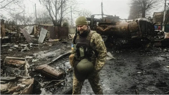 Ukrainian soldiers inspecting the wreckage of a destroyed Russian armored column on a road in Bucha, a suburb just north of the Capital, Kyiv.