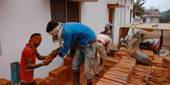 Two people moving bricks.