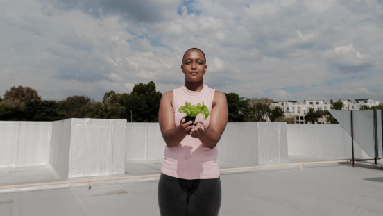 A woman holding a small plant in her hands