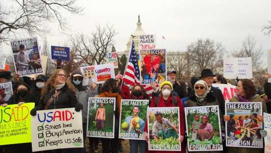 Protesters with signs gather at a rally in support of the U.S. Agency for International Development.