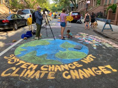 A chalk drawing of the earth saying "system change not climate change"