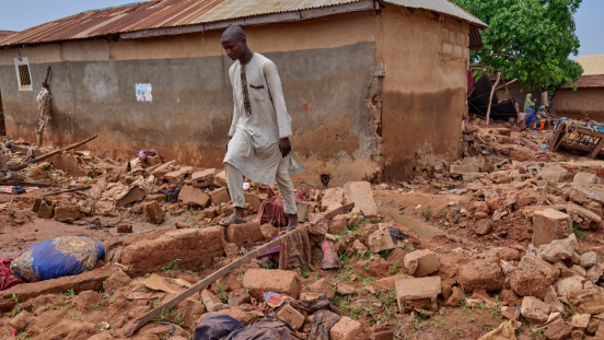 A young man walks through the aftermath of a flash-flood in Nigeria.