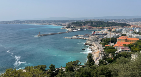 Photo of coast line with blue ocean to left and French city to right
