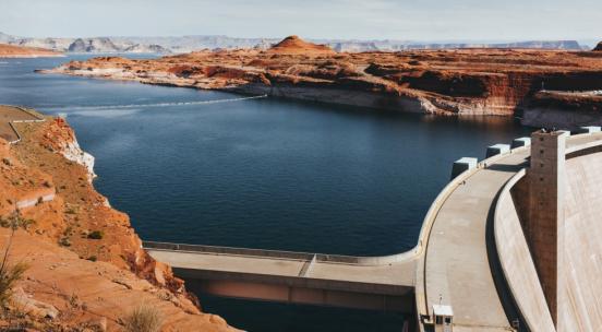 Photo of water dam in dessert environment with bridge infrastructure
