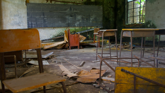A damaged classroom in the ruins of a school.