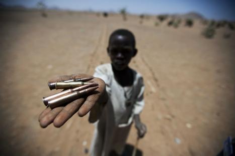 A boy holds up bullets in Darfur.