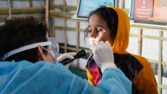 a child getting their throat checked at a refugee camp in Bangladesh