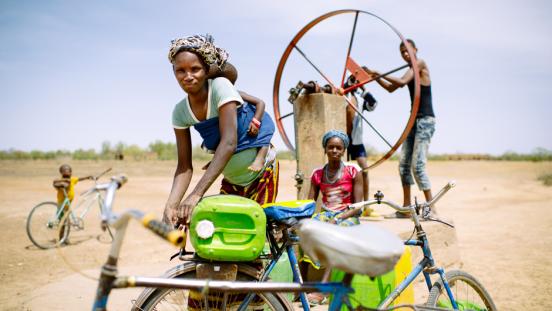 Barry Aliman, 24 years old, bicycles with her baby to fetch water for her family, Sorobouly village near Boromo, Burkina Faso.