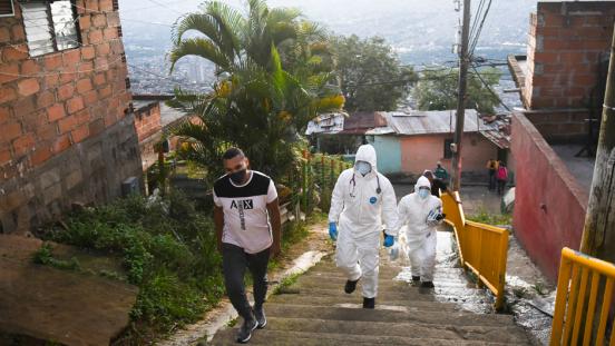 Paramedics wearing special suits look for a person who may have COVID-19 in the Comuna 1 neighborhood amid the COVID 19 pandemic.