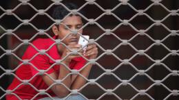 Man browses his mobile phone while waiting in Dhaka