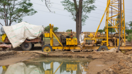 Indian man next to a groundwater pumping machine