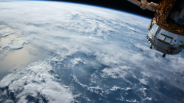 View of ocean clouds seen from space, with a satellite in the corner of the picture