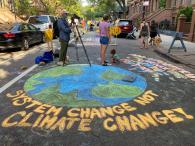 A chalk drawing of the earth saying "system change not climate change"