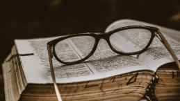 A pair of glasses on top of an open book