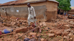 A young man walks through the aftermath of a flash-flood in Nigeria.