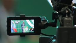 Press briefing seen through a video camera screen