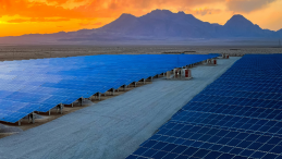 Field of solar panels against a mountain background
