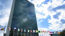 Secretariat building with flags of Member States in the foreground, at UN Headquarters.