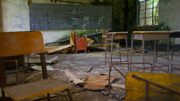 A damaged classroom in the ruins of a school.