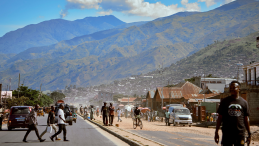 A street in the Democratic Republic of the Congo with mountains in the background.