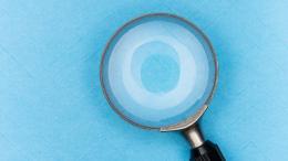 A magnifying glass on blue paper