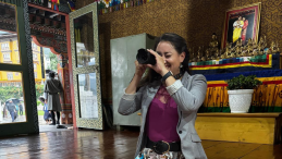 A woman takes a photo of something with a professional camera. 
