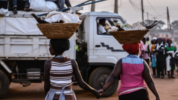 Two Nigerian women carrying baskets on their heads. 