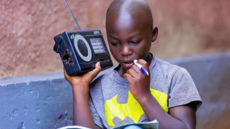 A boy listening to the radio and studying