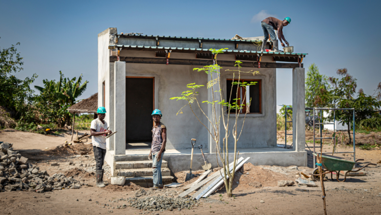 Three men working on a house in Mozambique. 