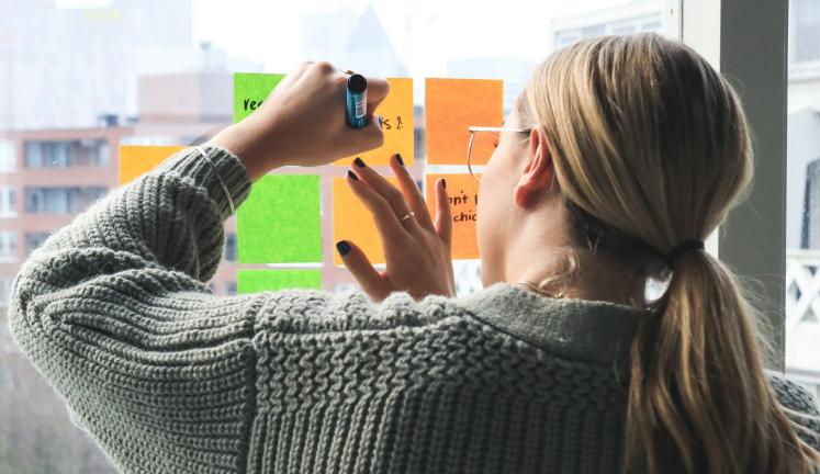 Student writing on sticky notes