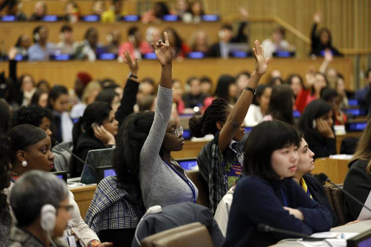 Women raising hands in meeting