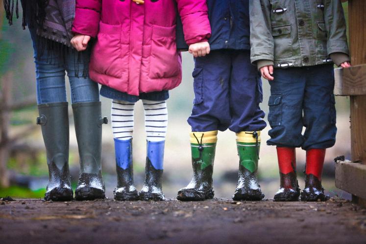 Children standing in a row, their faces not visible