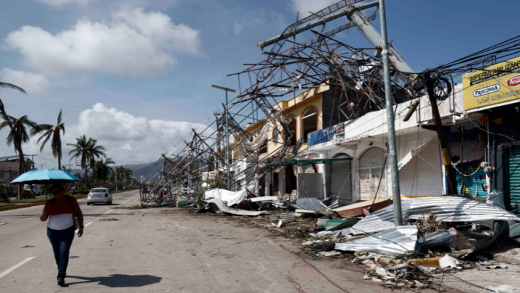 A person walks near the damage from Hurricane Otis in Alcapulco, Mexico. 