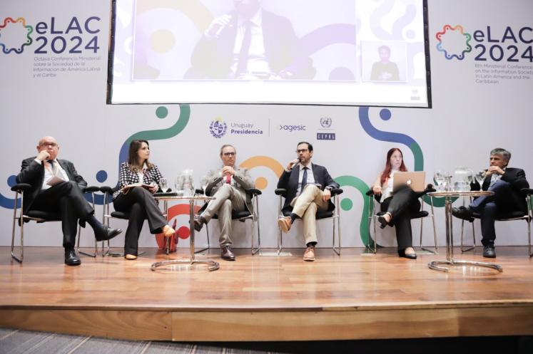 six individuals seated as part of panel discussion