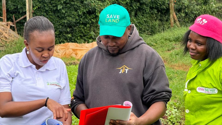 Three people in a field reading something