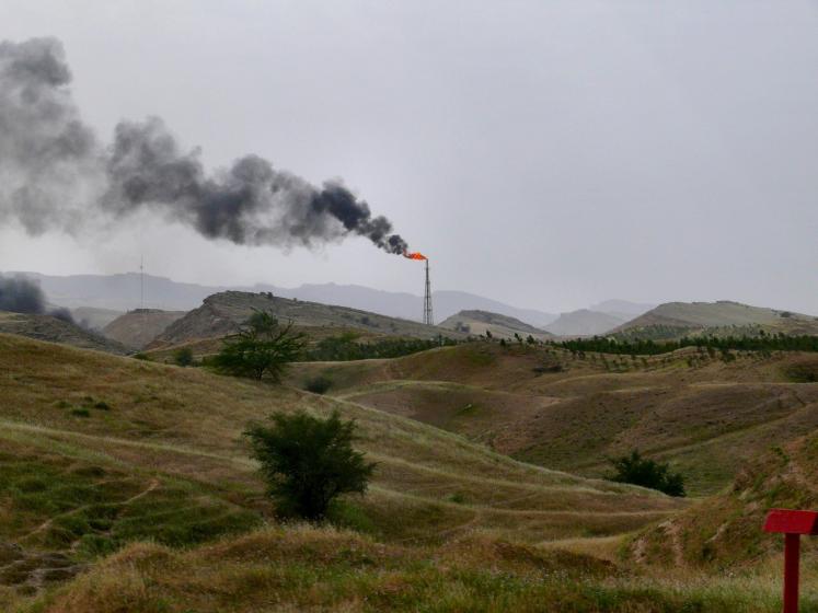 Dark smoke from a gas chimney, Gas & oil fields near Ahwaz, Khuzestan province, Iran, April 2008.