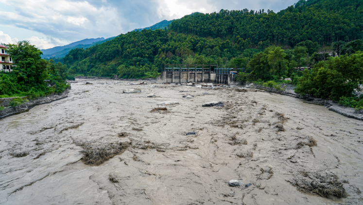 A flooded river breaks its way through a valley.
