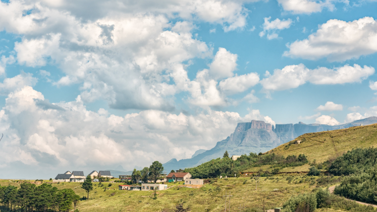 View of a tableau mountain landscape against a blue sky with many little white clouds 