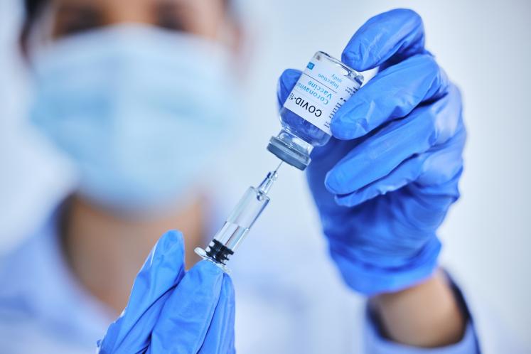 A healthcare worker prepares a COVID-19 vaccine dose for administration, supporting immunization efforts to prevent severe illness and reduce the spread of the virus. May 25, 2024.