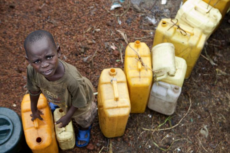 Child with plastic water containers.
