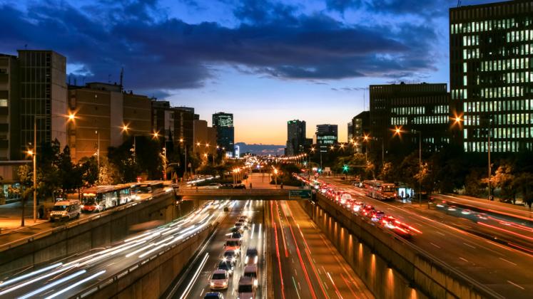 A busy road complex full of automobiles in twilight in Barcelona, Spain.