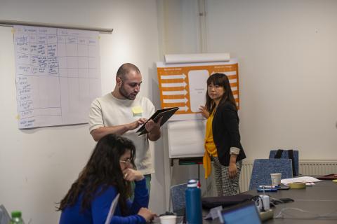 Image of two students and a teacher working on a project